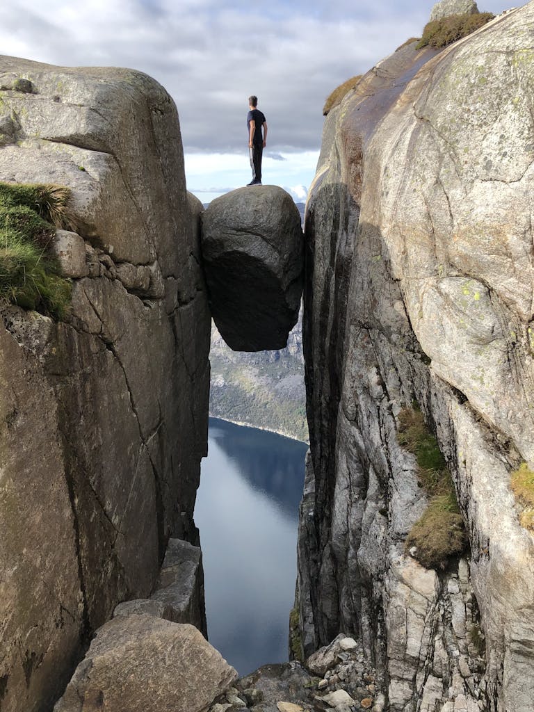 Person Standing on a Rock Stocked Between Rocks